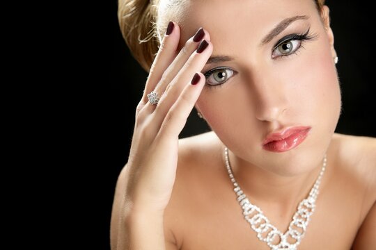 Blond elegant thinking fashion woman with jewelry on black