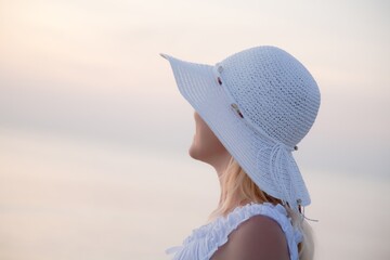 Young woman in the hat on the beach