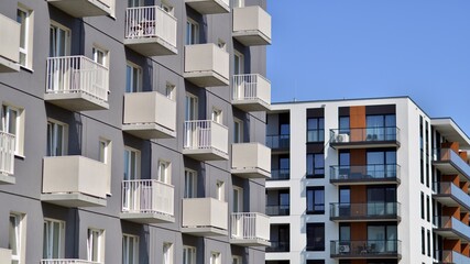 Apartment building with bright facades. Modern minimalist architecture with lots of square glass windows and balconies.