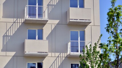 Apartment building with bright facades. Modern minimalist architecture with lots of square glass windows and balconies.