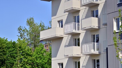 Apartment building with bright facades. Modern minimalist architecture with lots of square glass windows and balconies.