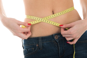 Beautiful girl measuring her waist with a measuring tape