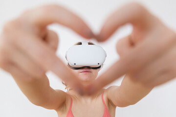 A girl in the vr headset showing heart shape gesture Love virtual reality