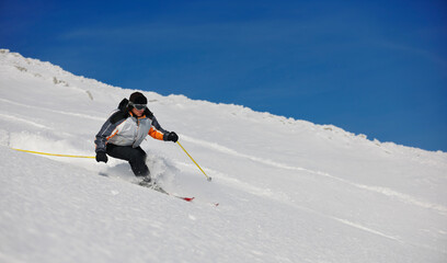 skier free ride downhill at winter season on beautiful sunny day