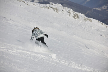 snowboard woman racing downhill slope and freeride on powder snow at winter season and sunny day