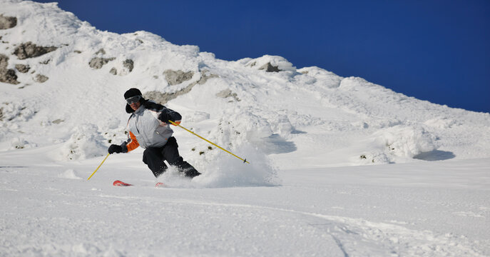skier free ride downhill at winter season on beautiful sunny day