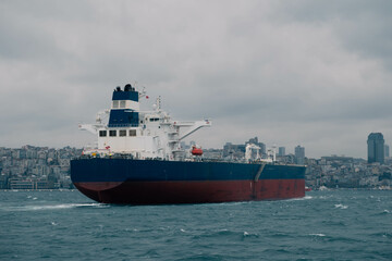 Fototapeta na wymiar An impressive stock photo showcases a cargo ship navigating through Istanbul's Bosphorus Strait on a cloudy day, capturing the essence of maritime charm and the city's iconic skyline.