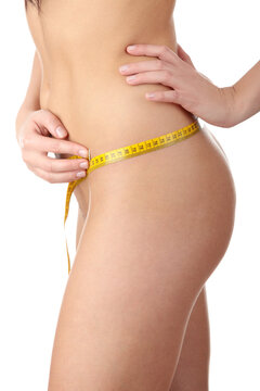 The beautiful girl measures her body on a white background. Healthy lifestyles concept.