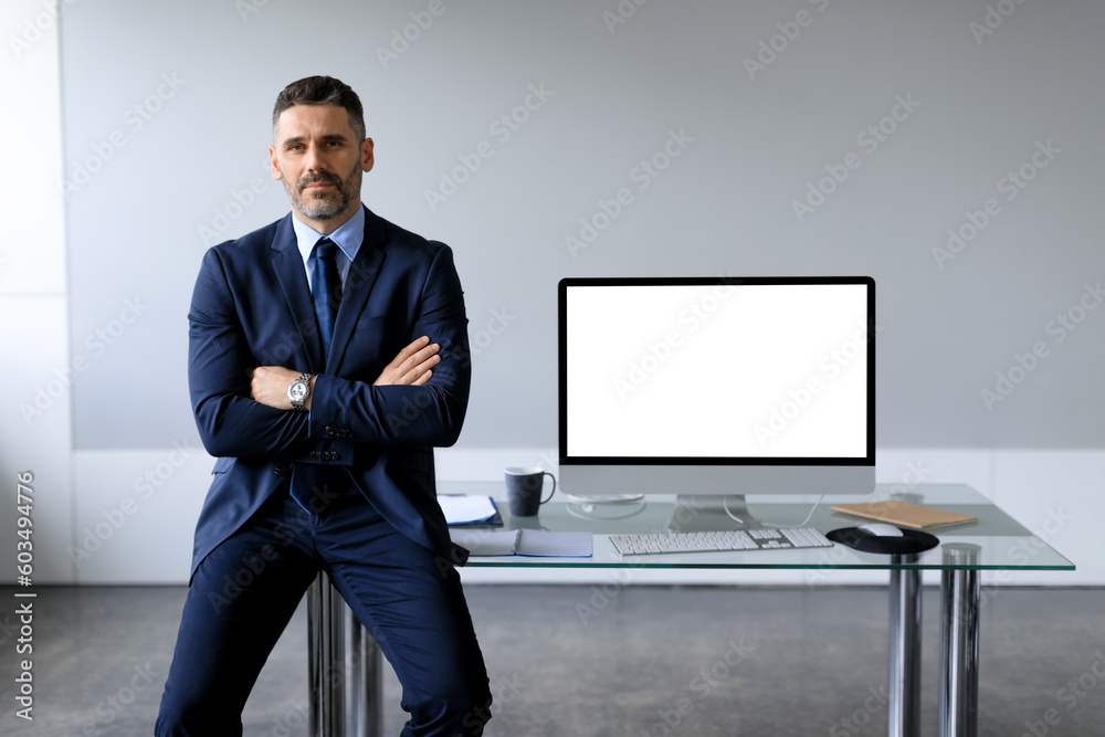 Aufkleber confident middle aged businessman leaning on table, posing with folded arms near computer with blank