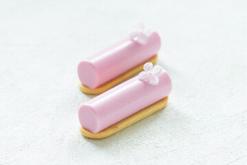 Cute Pitaya cream dessert in the form of a candy bar, decorated with a small flower. On cookie. White background