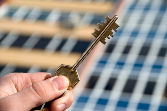 On a background of a modern brick house, hand with keys from an apartment.