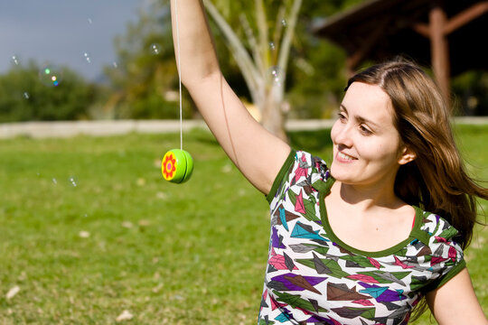 Young woman playing yo-yo in the park