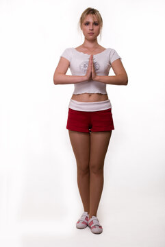 Full body of an attractive blond woman wearing workout attire standing in yoga pose over white