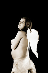 Pregnant woman on a black background with angel wings