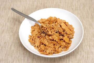 Simple bowl and cornflakes on a brownish beige mat
