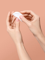 Woman hand holding a clean cotton disk. Applying cosmetic products or pilling nail polish. Fingernail, hand and body care concept. Image for beauty salon, cosmetologist or manicure artist promotion.
