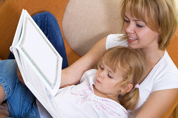 Woman and little girl story time at home