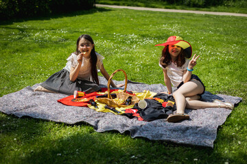 Portrait of two girls in a hat of the Belgian flag in the park on a picnic.
