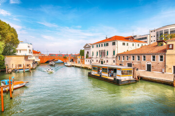 Obraz premium Fabulous cityscape of Venice with narrow canals, boats and gondolas and bridges with traditional buildings