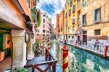 Gorgeous cityscape of Venice with narrow canals, boats and gondolas and bridges with traditional buildings