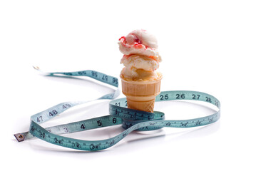 Concept image of a diet featuring an ice cream cone with strawberry ice cream and a measuring tape shot on white