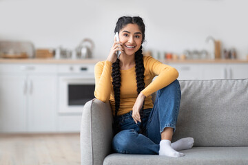 Portrait Of Beautiful Young Indian Woman Talking On Mobile Phone At Home