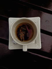 White porcelain cup and saucer resting on varnished noble wood