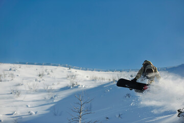 freestyle snowboarder jump and ride free style  at sunny winter day on mountain
