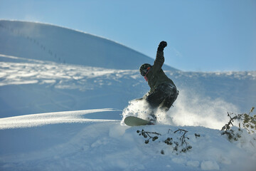 freestyle snowboarder jump and ride free style  at sunny winter day on mountain