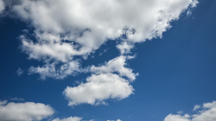 Obłoki chmur typu Cumulus na błękitnym niebie w słoneczny dzień