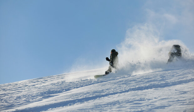 freestyle snowboarder jump and ride free style  at sunny winter day on mountain