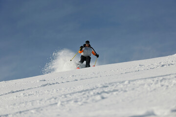 skier free ride downhill at winter season on beautiful sunny day