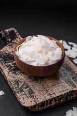 Fototapeta na wymiar White dry coconut flakes in a wooden bowl prepared for making desserts