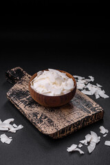 White dry coconut flakes in a wooden bowl prepared for making desserts
