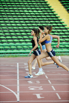 three athlete woman running on athletics race track on soccer stadium and representing competition concept in sport