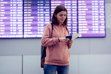 Young woman is waiting for the boarding on the plane at the airport.