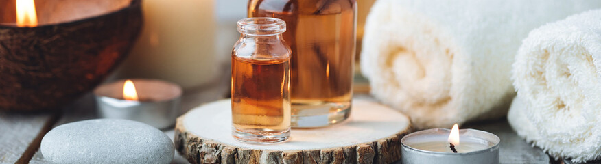 Concept of spa treatment in salon with pure organic natural oil. Atmosphere of relax, detention. Aromatherapy, candles, towel, wooden background. Skin care, body gentle treatment