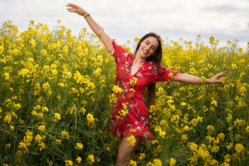 Naklejka premium Beautiful latino woman in floral dress in a canola field