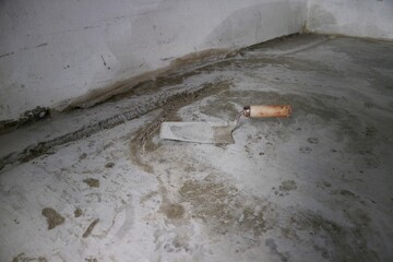 Сloseup applying micro concrete plaster coating on the floor with a trowel. Trowel on the concrete floor.