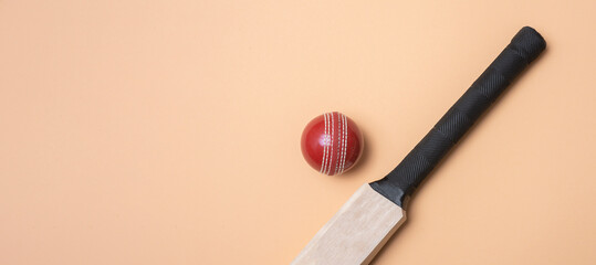 Cricket bat and red balls on beige background. Horizontal sport theme poster, greeting cards, headers, website and app