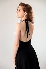 Fototapeta premium young girl in a black dress on a white background