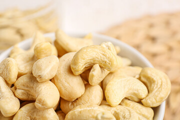 Bowl with tasty cashew nuts on table, closeup