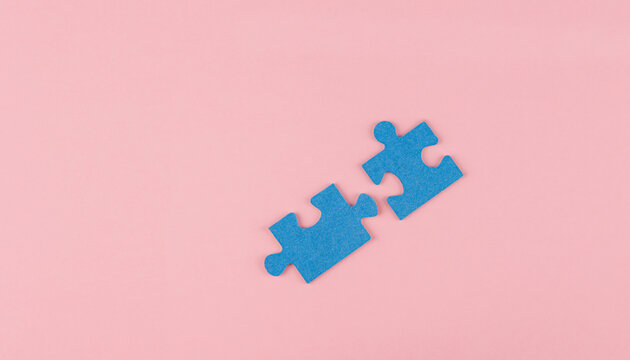 Two Blue Colored Jigsaw Puzzle Pieces Coming Together On A Pink Colored Background, Concept Of Union, Teamwork, Compliment, Whole