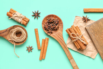 Composition with anise stars, cinnamon sticks, powder and rope on color background
