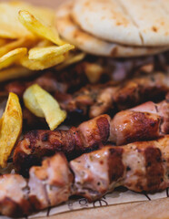 View of Souvlaki on a plate - traditional greek cuisine dish with grilled bbq chicken with french...