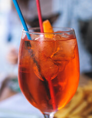 Orange red colored aperitif alcohol cocktails on a party, beautiful view of alcohol setting on banquet table, row line of negroni, spritz and others on a date celebration in a restaurant, summer day