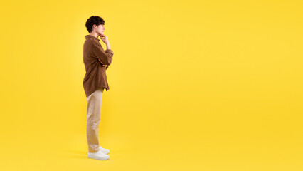 Fototapeta na wymiar Thoughtful Guy Thinking Looking Aside At Empty Space, Yellow Background
