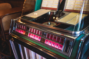 Vintage American music jukebox with illuminated buttons, process of choosing song composition,...