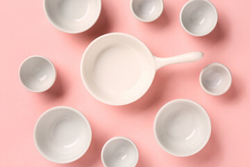 Composition with clean bowls and cup on pink background