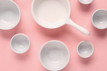 Composition with clean bowls and cup on pink background